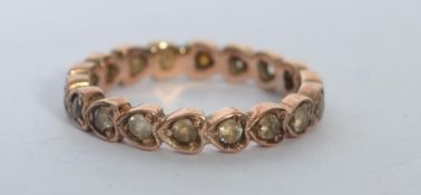 A  9ct gold eternity ring set with clear stones in heart shaped settings. Marked 9ct tests 9ct gold.
