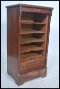 An early 20th Century oak filing cabinet, with tambour front over nine internal shelves, panelled