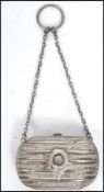 A Victorian silver hallmarked ladies penny purse with chain. Of lozenge form with plain cartouche