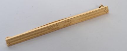 An An early 20th Century 14ct gold bar brooch with scroll decoration, having a clip C clasp.