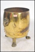 A 19th century Victorian brass coal scuttle bucket raised on three paw feet with lion mask drop