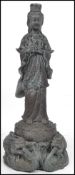 A large Oriental Chinese bronze statue of a Buddha holding a water bottle raised on a floral base