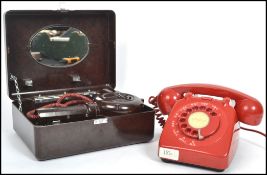 A vintage Bakelite cased hairdyer together with a red ring dial telephone with red cord and a-z