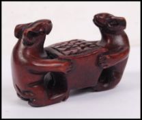 An Oriental carved novelty figure of two mice carrying a box.