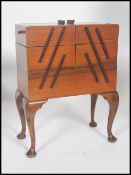 A mid century Victorian style concertina metamorphic sewing box with opening sections raised on