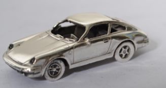 A sterling silver motoring miniature model of a Porsche 911, stamped to verso 925 with makers
