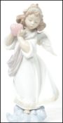 A Lladro ceramic figurine entitled ' Loving The World '  depicting an angel with flowers to hair