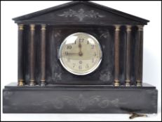 An early 20th century black marble slate mantel clock, raised on a block plinth with columned