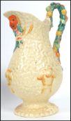 A Clarice Cliff Celtic Harvest pattern jug with fruit handle and wheatsheaf decoration, with printed