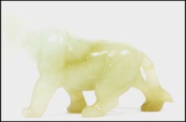 An Oriental Chinese jade carving of a dog / temple lion with open jaw and hanging tongue.