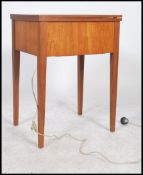 A vintage retro teak wood metamorphic sewing machine wraised on square legs.oak table, having a flip