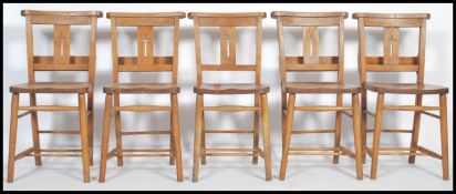 A set of five vintage elm chapel chairs fitted with hymnal tray, curved top rail, turned supports