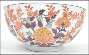 A large Oriental ceramic bowl having a white ground with decoration of birds and flowers having