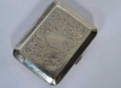 A silver hallmarked contemporary cheroot case having a chased scrolled decoration with sloped edges.