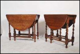 A pair of 20th century Oak drop leaf oval topped barley twist gate legged dinning tables.