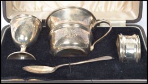 A four piece cased silver hallmarked christening set, consisting of egg cup, beaker, napkin ring and
