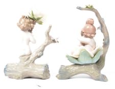 A pair of Lladro ceramic figurines of a male and female cherub mounted on a log with large ceramic