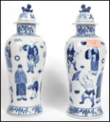 A pair of Oriental Chinese blue and white vases with lids having bands of floral decoration and