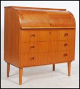 A retro 20th century Danish inspired teak wood roll top desk having an appointed interior and raised