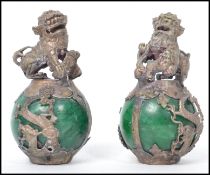 A pair of Oriental Chinese Temple Fu Lion Dogs of silver white metal construction mounted on