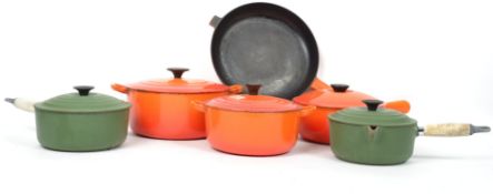 A collection of vintage 20th century kitchenalia Le Cruset frying pans an cooking points in orange