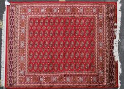 A large Iranian / Persian Bokhara carpet - rug having red ground with geometric decoration and