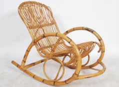A vintage 20th century retro designer bamboo rocking chair of unusual form in the manner of Louis