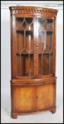 A Georgian style mahogany bow front corner cabinet of good quality having twin astragal glazed