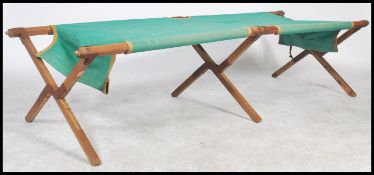 An early 20th century believed military folding campaign style canvas bed. Beech wood construction