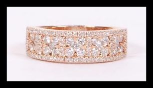 An 18ct gold diamond half eternity ring of grid form having clusters of five diamonds surrounded