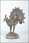 A continental silver filigree model of a peacock raised on a circular pierced base. Weighs 76.4