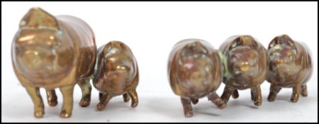 A group of 19th century Victorian brass lead filled novelty pigs paperweights, one joined pair and