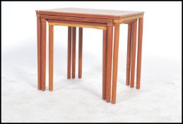 A good Danish 1960's teak wood graduating nest of tables being raised on turned legs with a series