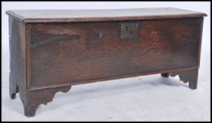 An 18th century joined elm country coffer chest having a wide carved panelled front being raised