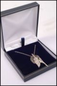 A sterling silver art deco style necklace and pendant having a winged angel in flight, complete in