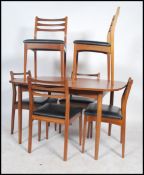 A set of 6 1970's retro teak wood rail back dining chairs raised over black vinyl pad seats together
