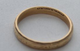 A hallmarked 9ct gold band ring with etched decoration. Hallmarked Birmingham. Total weight 1.8g.