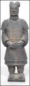 A large Oriental Terracotta  army figure of a soldier raised on a square plinth base with