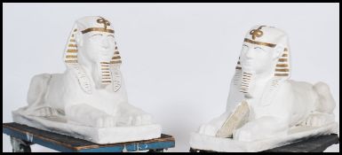 A large pair of cast stone garden ornament features in the form of Egyptian Sphinx. Each painted