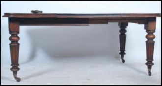 A good Victorian mid 19th century wind out extending dining table being raised on reeded tapering