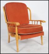 A 1970's retro Ercol style armchair of beech wood construction being raised on turned legs having