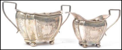 A silver hallmarked creamer jug and matching sugar bowl, decorated with chase decorated fauna