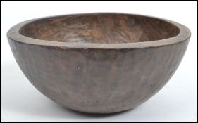An Indian wooden bowl having an adds carved snakeskin design with flat base. Measures 16 cm high and