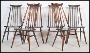 A set of 6 Ercol 1970's ' Goldsmith ' beech and elm wood dining chairs being raised on turned legs