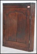 An 18th century Georgian solid oak country corner cabinet having single door with shelved interior