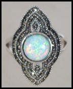 A silver Art Deco style ladies dress ring having a large central opal surrounded by marcasite's/