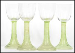A group of four early 20th century Hock wine glasses, each glass raised on a ribbed tapering stem