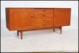A  mid century Danish manner sideboard - dresser being raised on tapering legs with a bow front