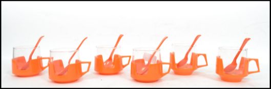 A set of six vintage retro 20th century JAJ Pyrex cups and spoons in Volkswagen orange having stamps