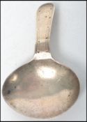 A Georgian silver caddy spoon of stub form bearing monogram with handle. The marks verso being